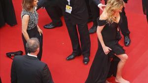 Julia Roberts camina descalça sobre l’alfombra vermella.