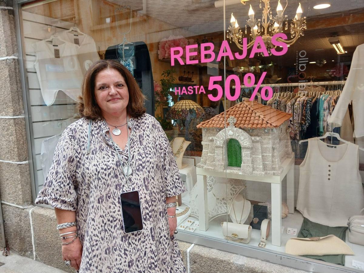 La responsable del comercio Regalía, Carmen Santos, ante el escaparate con la llamativa réplica a escala de capilla de Santos Reis.