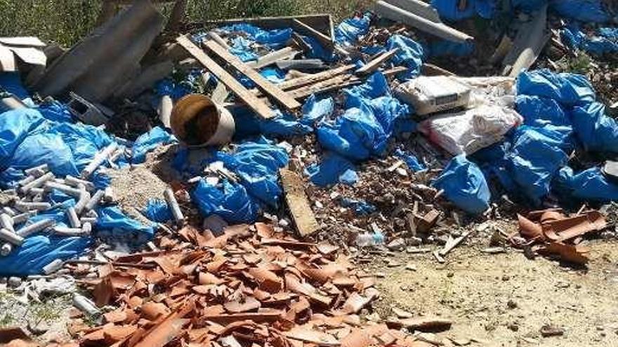 Una parcela de Bergondo se convierte en depósito de contenedores en desuso, escombros de obras, neumáticos y restos de poda, entre otros residuos