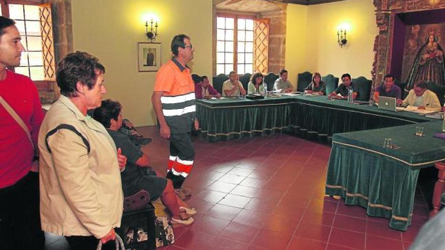 Los trabajadores abandonan el pleno contrariados tras aprobarse los despidos.