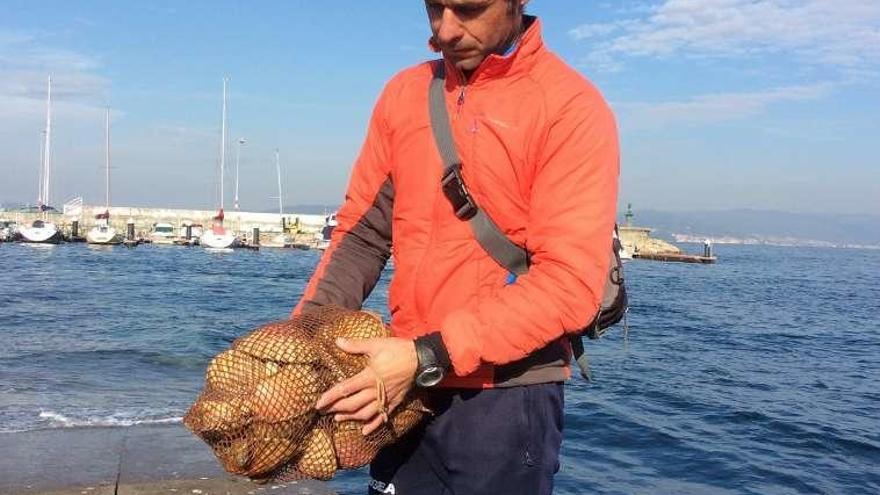 Un marinero de Bueu con el muestreo de vieira para analizar. // S.Á.