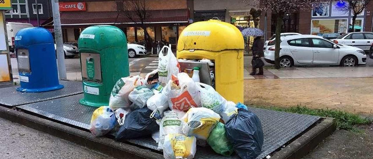 Un punto de recogida separada saturado de basura.