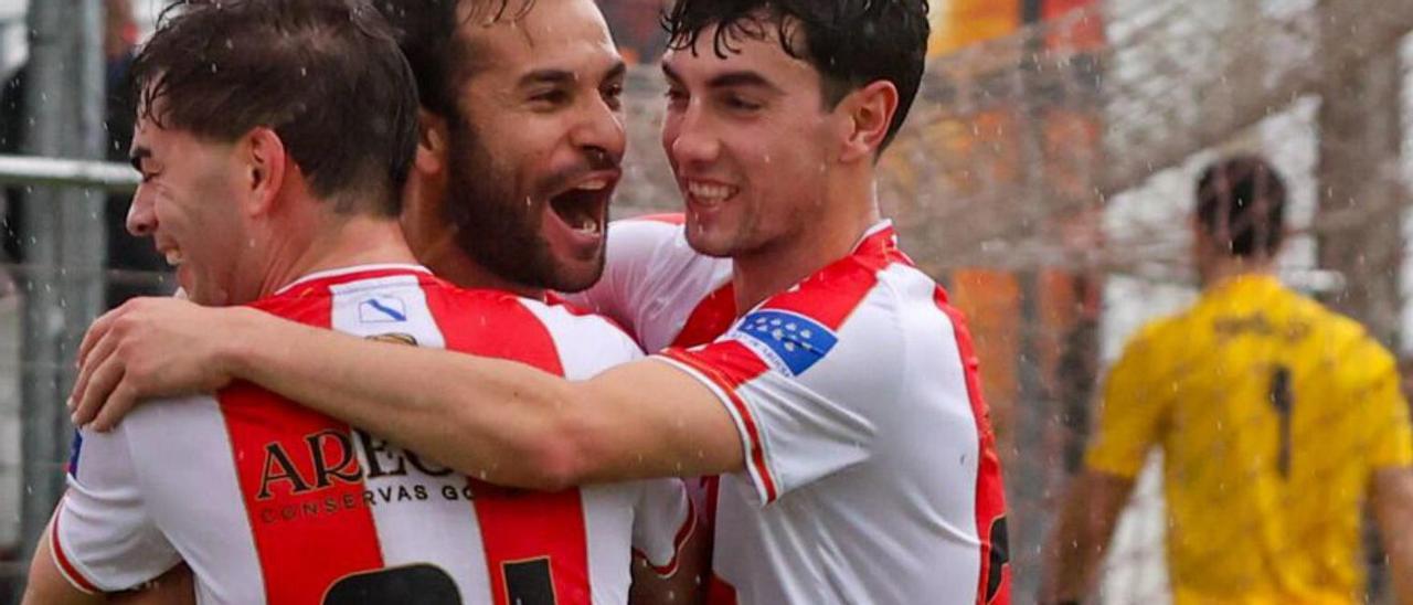 Adri Rodríguez celebra un tanto con dos compañeros.