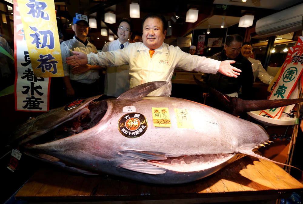 El presidente de Kiyomura Co's -una cadena de restaurantes de sushi-, Kiyoshi Kimura (C),posa con un atún azul de 212 kg que ganó en una subasta al ofrecer por él 74 millones de yenes (cerca de 600.000 euros) en la primera subasta de atún del año en Japón.