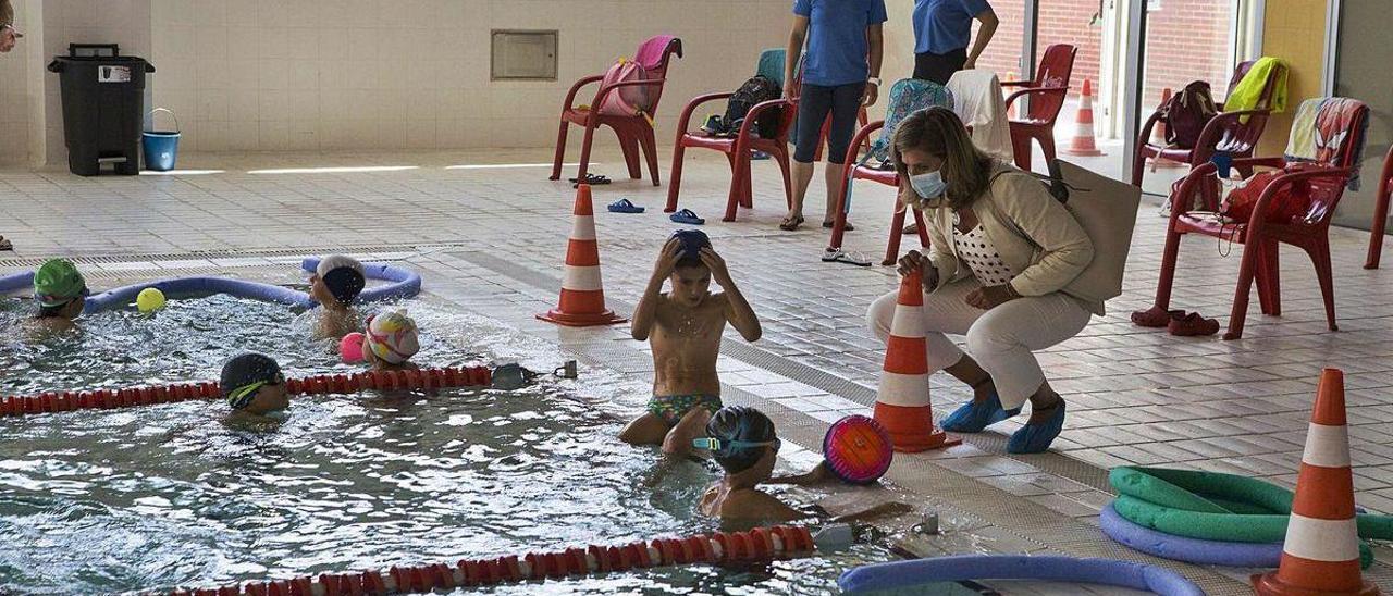 Conchita Méndez, agachada, durante una visita a las piscinas del Parque del Oeste.