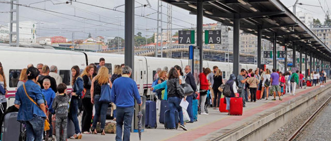 Viajeros esperando en la estación de Guixar en Vigo. // Marta G. Brea