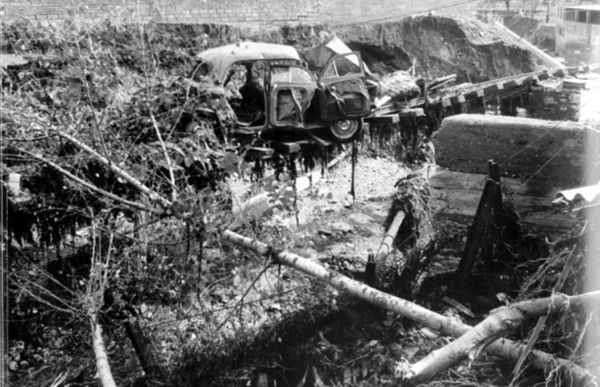 La força de l’aigua arrossega un cotxe pràcticament destrossat sobre un pont a punt d’ensorrar-se.