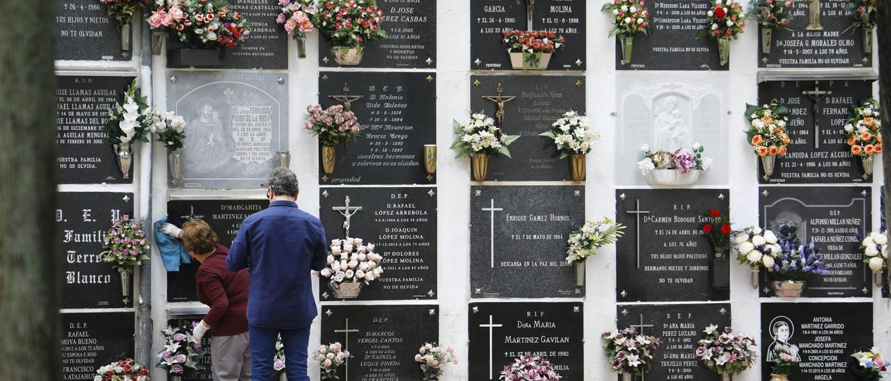 Dos personas visitan un cementerio.