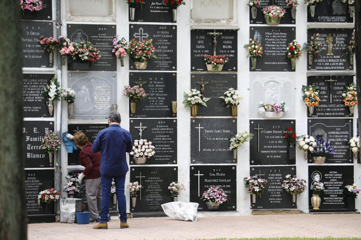 Dos personas visitan un cementerio.