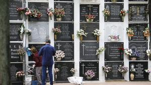 Dos personas visitan un cementerio.