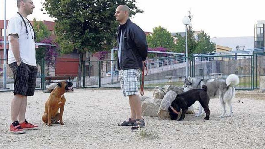 Dos propietarios de perros pasean sus mascotas en el parque Joaquín García Picher.  // José Lores