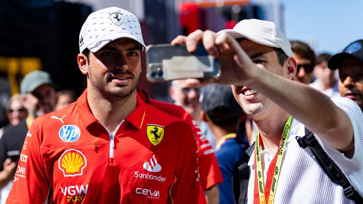 Carlos Sainz del equipo Ferrari se fotografía con un seguidor en el Circuit de Barcelona