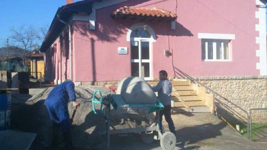 Dos operarios trabajando en la rampa en Mestas de Con, ayer.