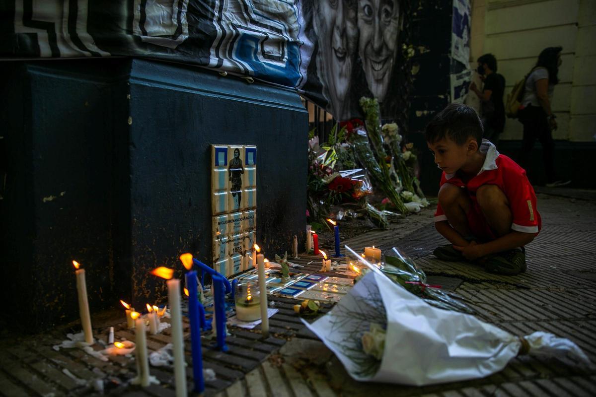 Un niño observa un altar improvisado en honor a Maradona en La Plata.