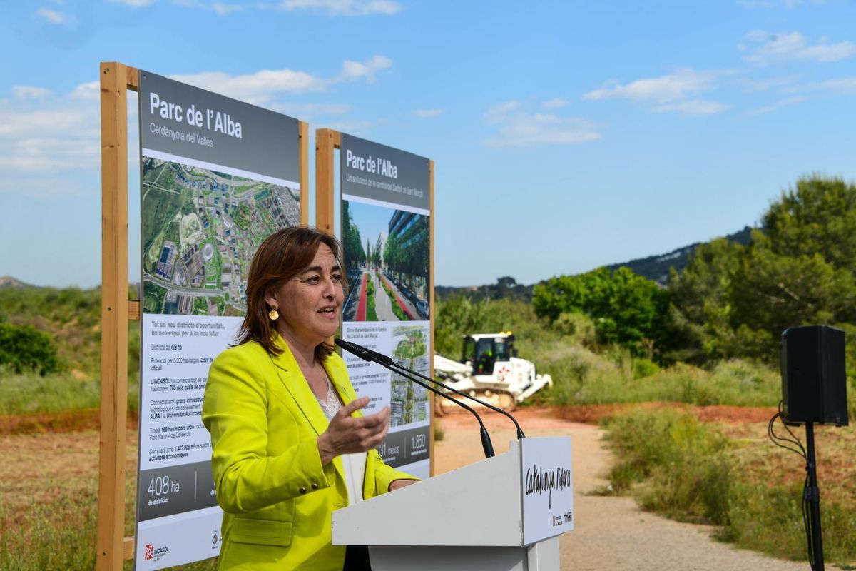 Una máquina excavadora trabaja detrás del escenario donde la consellera Sílvia Paneque ha celebrado el inicio de los trabajos para construir 5.000 viviendas en el Parc de l'Alba, en Cerdanyola.