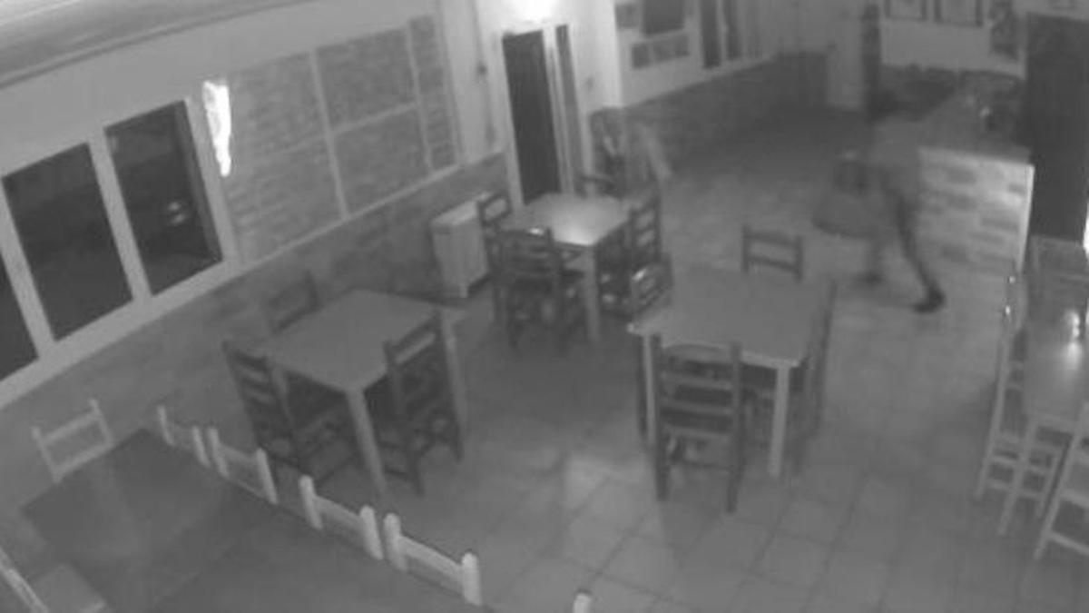 Imágen de la cámara de seguridad con el ladrón en la esquina superior derecha, junto a la barra del bar
