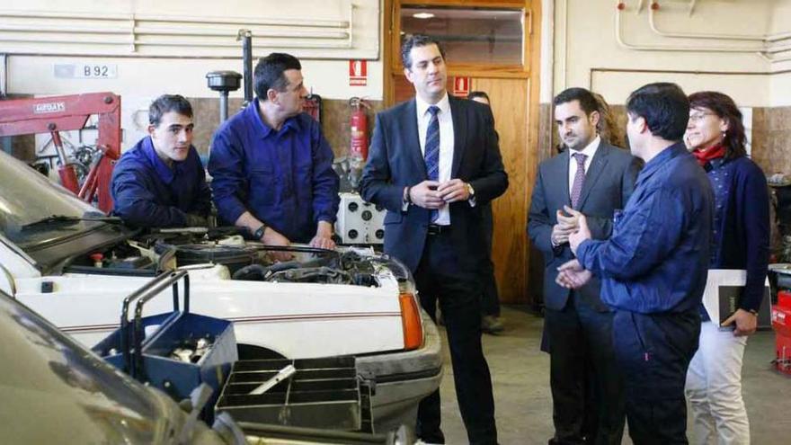 Alberto Castro y Efrén Fernández, de traje, conversan con los alumnos de los cursos de mecánica.