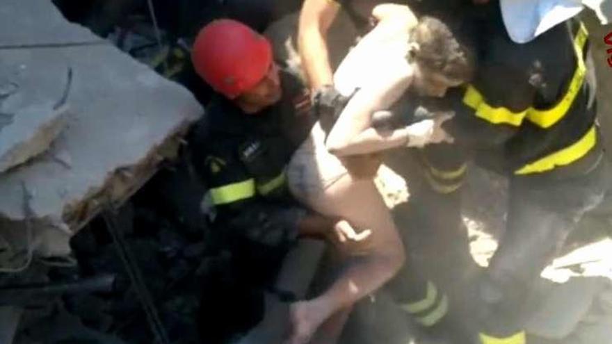 Los bomberos italianos rescatan a uno de los niños sepultados.