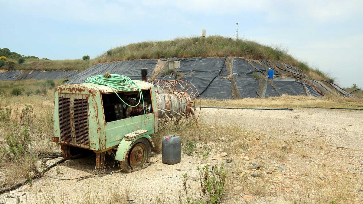 Part de l&#039;estat actual de l&#039;abocador de Vacamorta, amb els plàstics que segellen les terreres i una màquina totalment rovellada