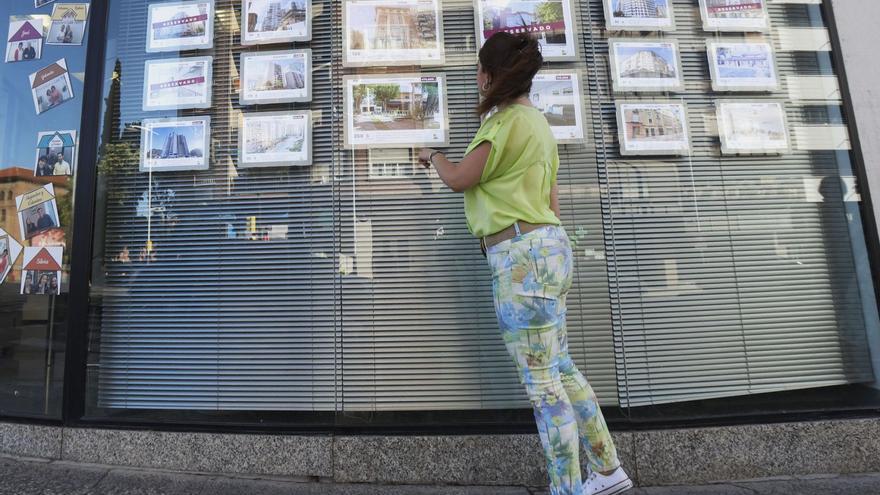 Una joven observa las ofertas de vivienda colgadas en el escaparate de una agencia de Zaragoza.  | ANDREEA VORNICU