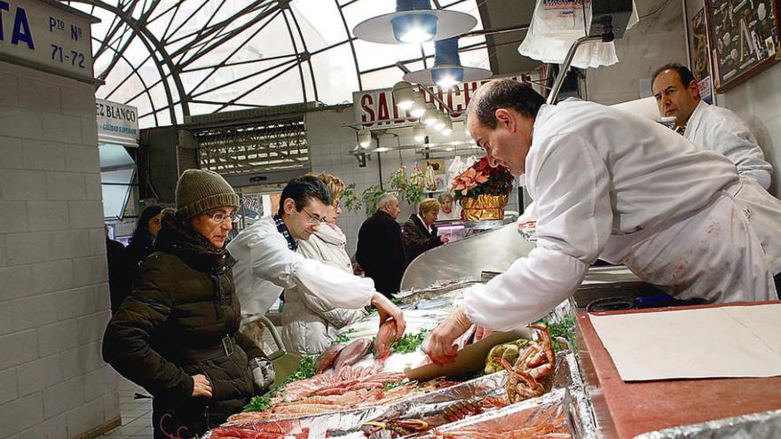 Consumidores en un puesto de producto marino dentro del Mercado de Abastos de Zamora.