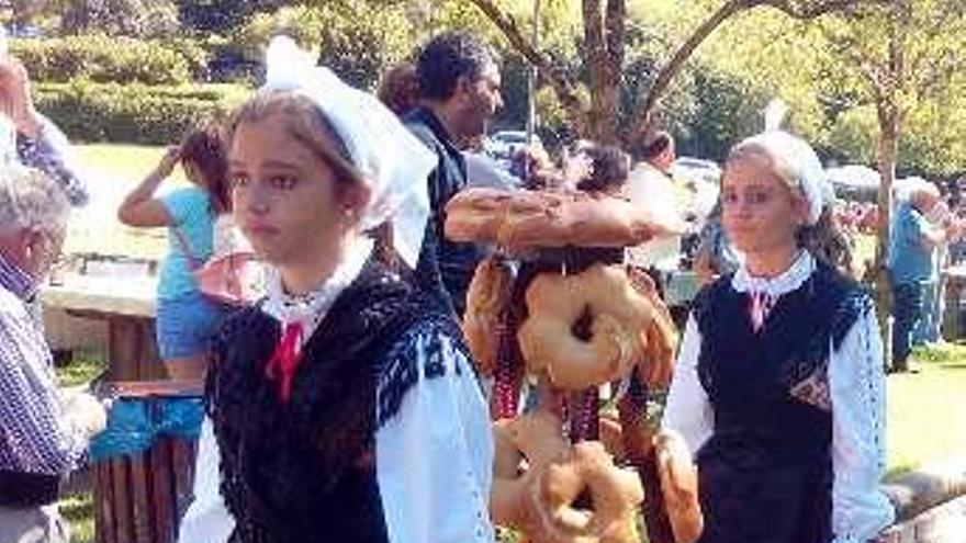 Sobre estas líneas, dos asturianas llevan el ramu. A la derecha, la imagen de la Virgen en la procesión de ayer.