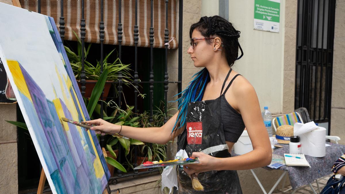 Mujer participa en un concurso de pintura al aire libre, imagen de archivo.