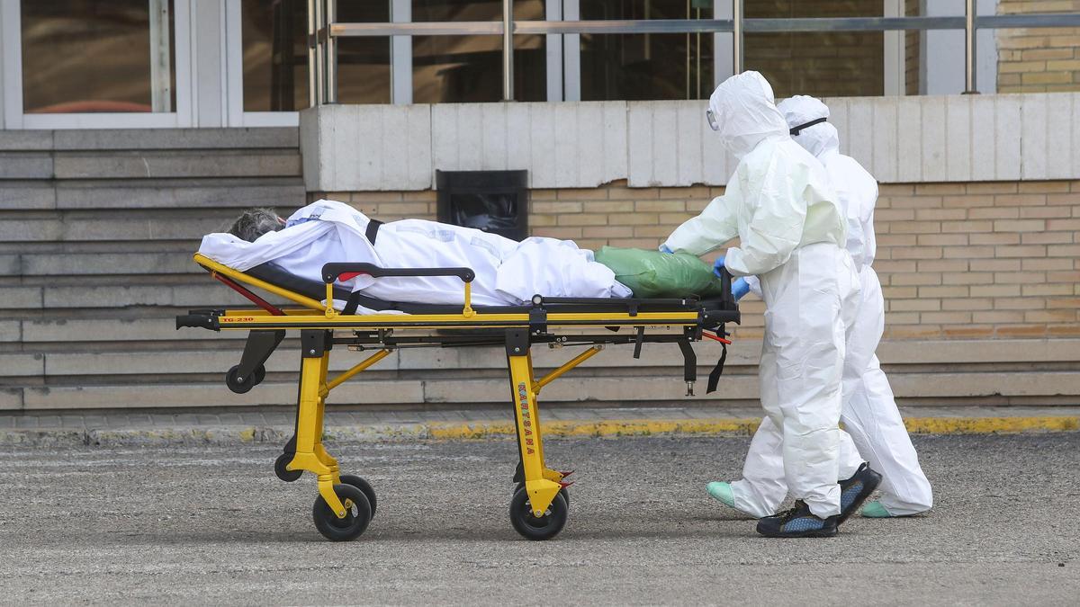 Sanitarios con sus equipos de protección individual (EPI) trasladando un paciente con covid al antiguo hospital la Fe de València en febrero de 2021.