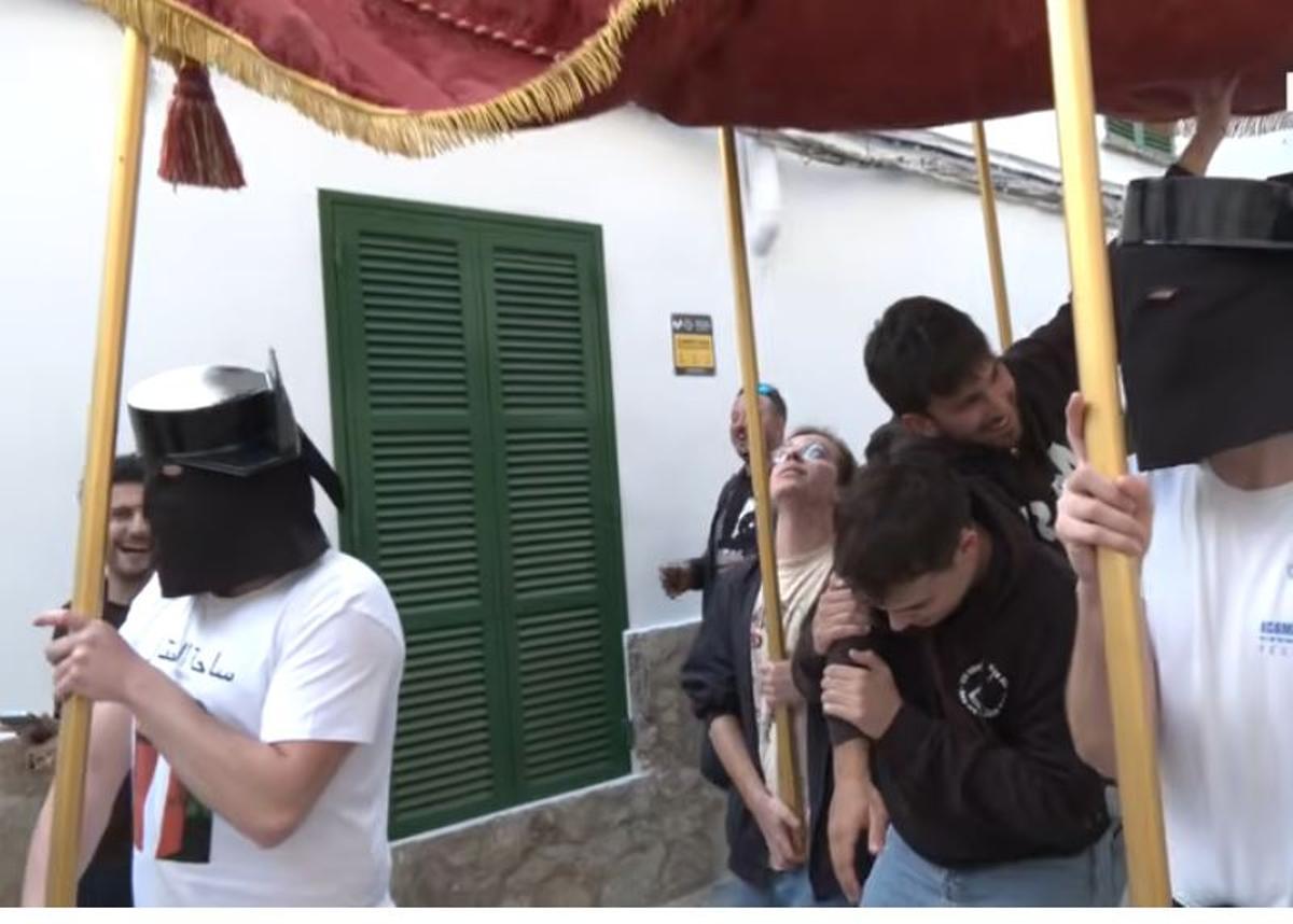 Un joven transportaba a otro sobre una cruz, escoltados por nazarenos con tricornios