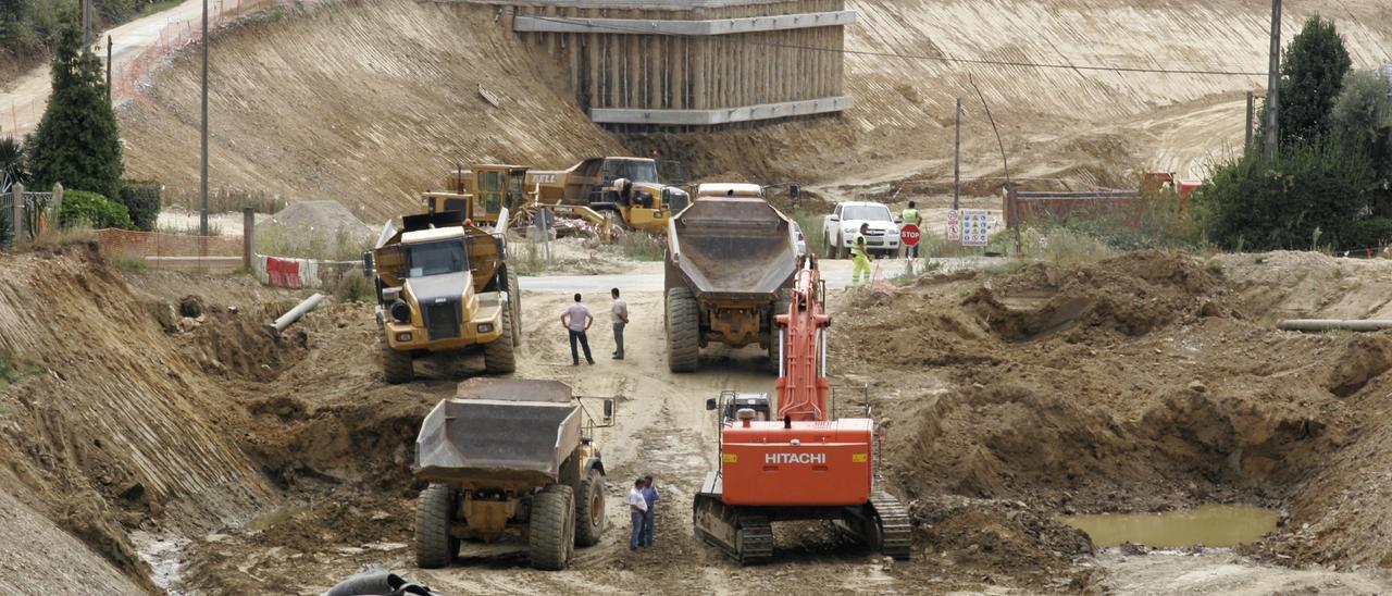 Operarios y maquinaria trabajando en una obra pública.