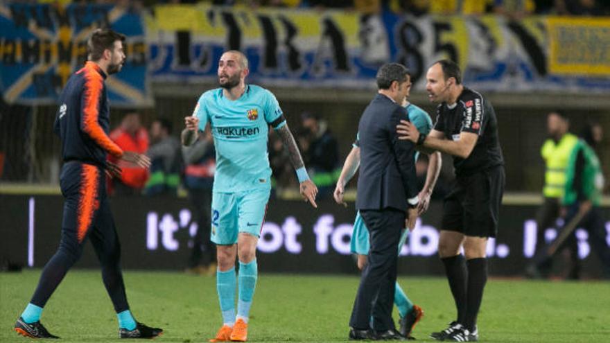 Mateu Lahoz da explicaciones al técnico azulgrana, Ernesto Valverde; por la izquierda, Piqué le recrimina su actuación.