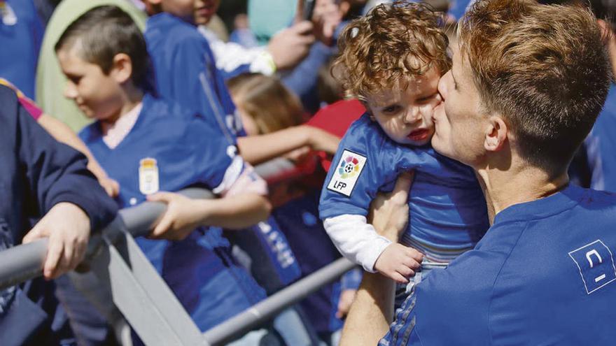 Susaeta coge en brazos a un niño enfundado en la camiseta azul, ayer en el Carlos Tartiere