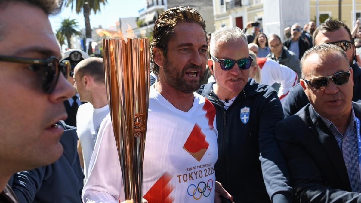 El actor Gerard Butler porta la antorcha en Esparta rodeado de numeroso público.