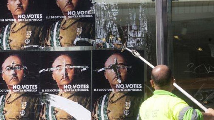 Un operari retira de Barcelona cartells amb la cara de Franco, ahir