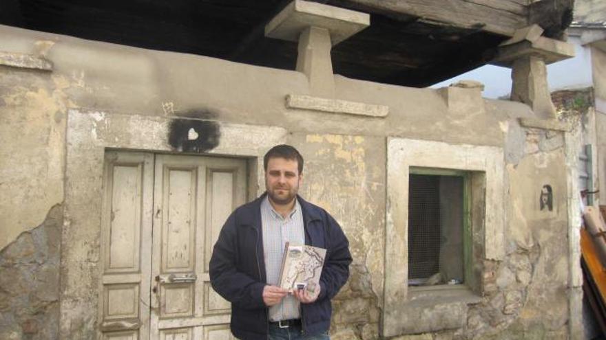 Gustavo Adolfo Fernández, con la guía etnográfica de hórreos, delante de una panera en La Ferrería, en Grado.