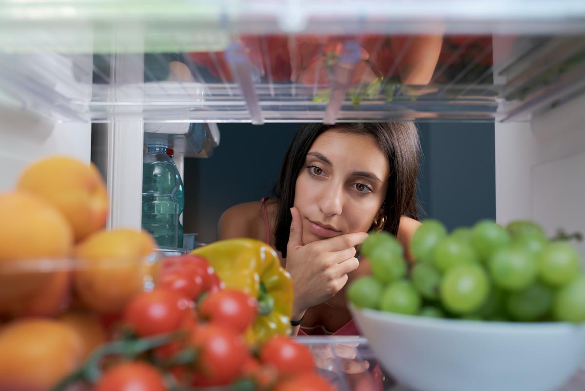 Una mujer observa el interior de su frigorífico