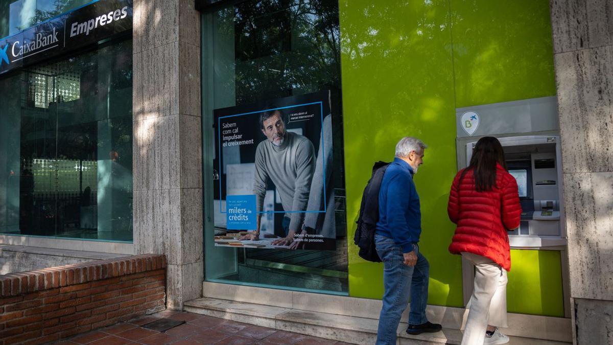 Uns clients dissabte en un dels caixers de l’antiga Bankia. | JORDI OTIX