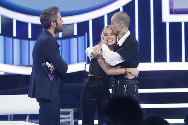 María abraza a su novio, Pablo, ante la curiosa mirada de Roberto Leal