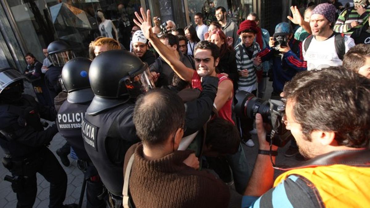 Agentes de los Mossos d'Esquadra intentan desalojar a los ciudadanos acampados frente a la Bolsa de Barcelona, este lunes.