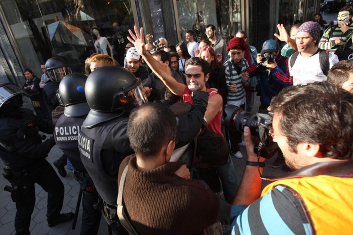 Agents dels Mossos d’Esquadra intenten desallotjar els ciutadans acampats davant la Borsa de Barcelona, aquest dilluns.