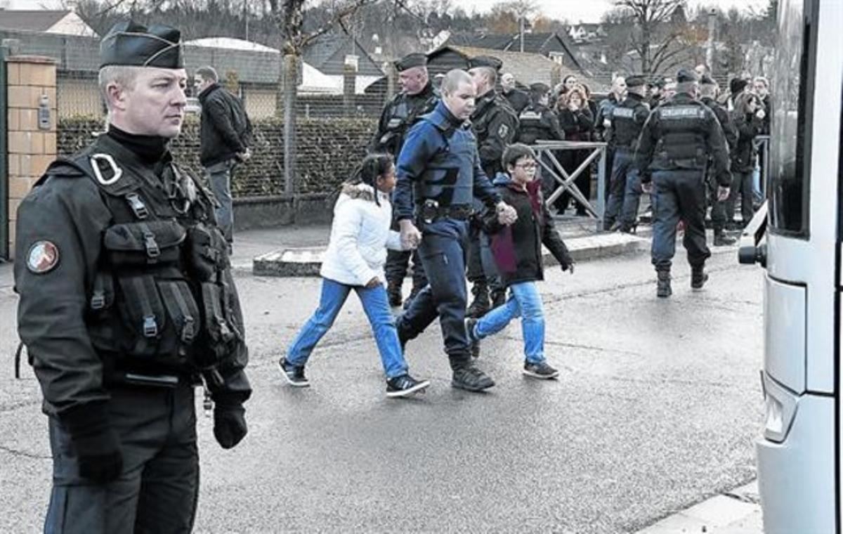 Varios policías intervienen en Dammartin-en-Göele. A la derecha, el Arco de Triunfo.