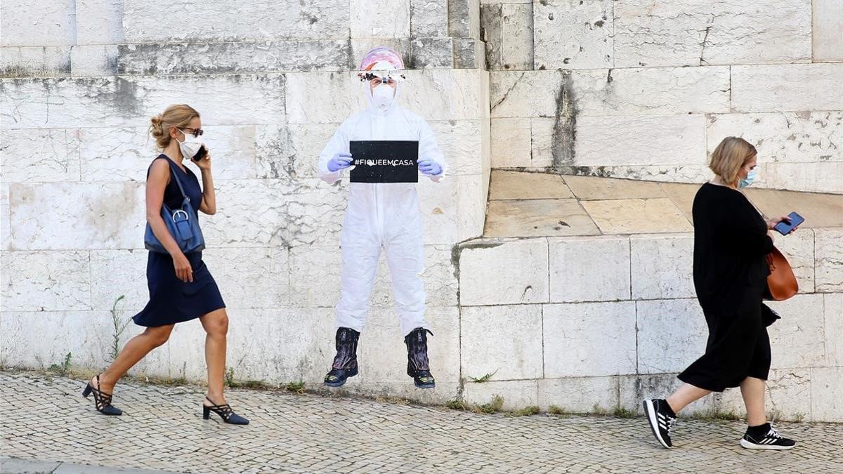 Dos viandantes con mascarilla en una calle de Lisboa (Portugal)