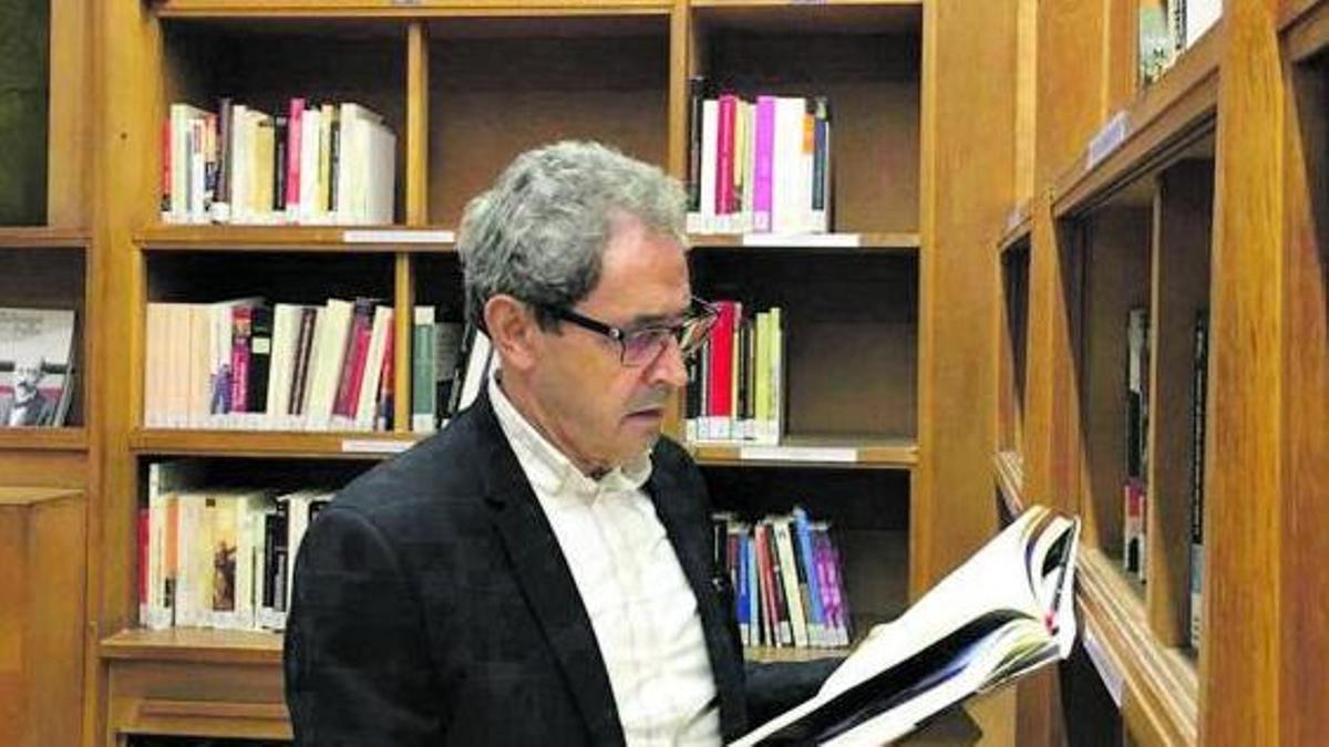 El zamorano revisa un libro en la biblioteca de la institución que dirige en París. |