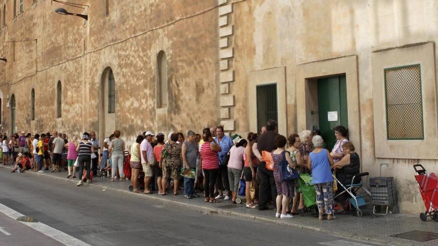 Cola de personas para recoger comida en Palma.