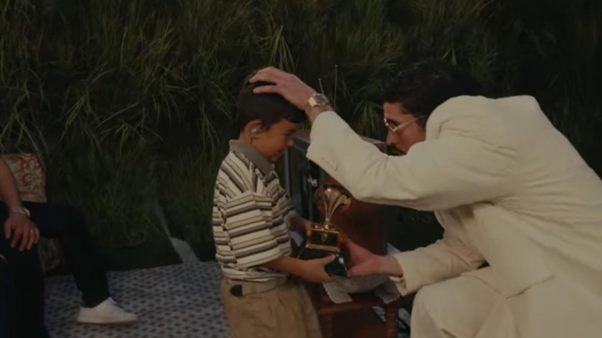 Bad Bunny entrega el premio Grammy a un niño.