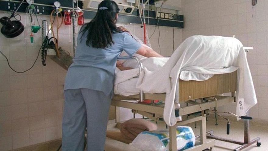 Una auxiliar de enfermería mueve a un paciente en un hospital
