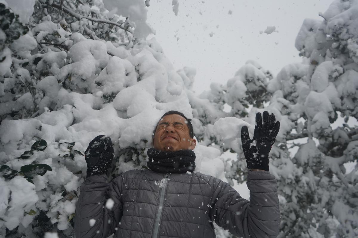 Un hombre se divierte con la nieve en las colinas de Chandragiri, en las afueras de Kathmandú.