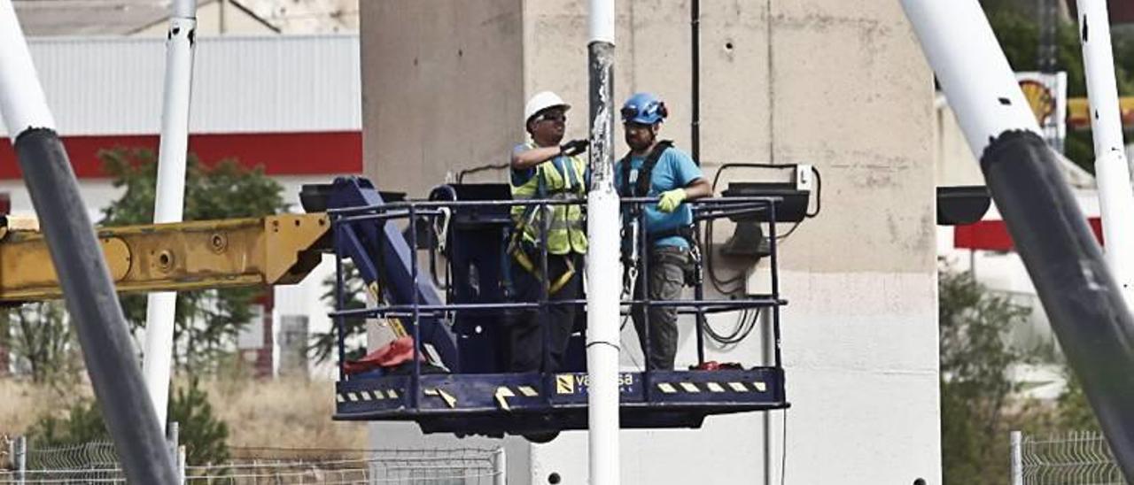 Operarios examinando en la tarde de ayer uno de los tirantes del puente Fernando Reig con la ayuda de una grúa.