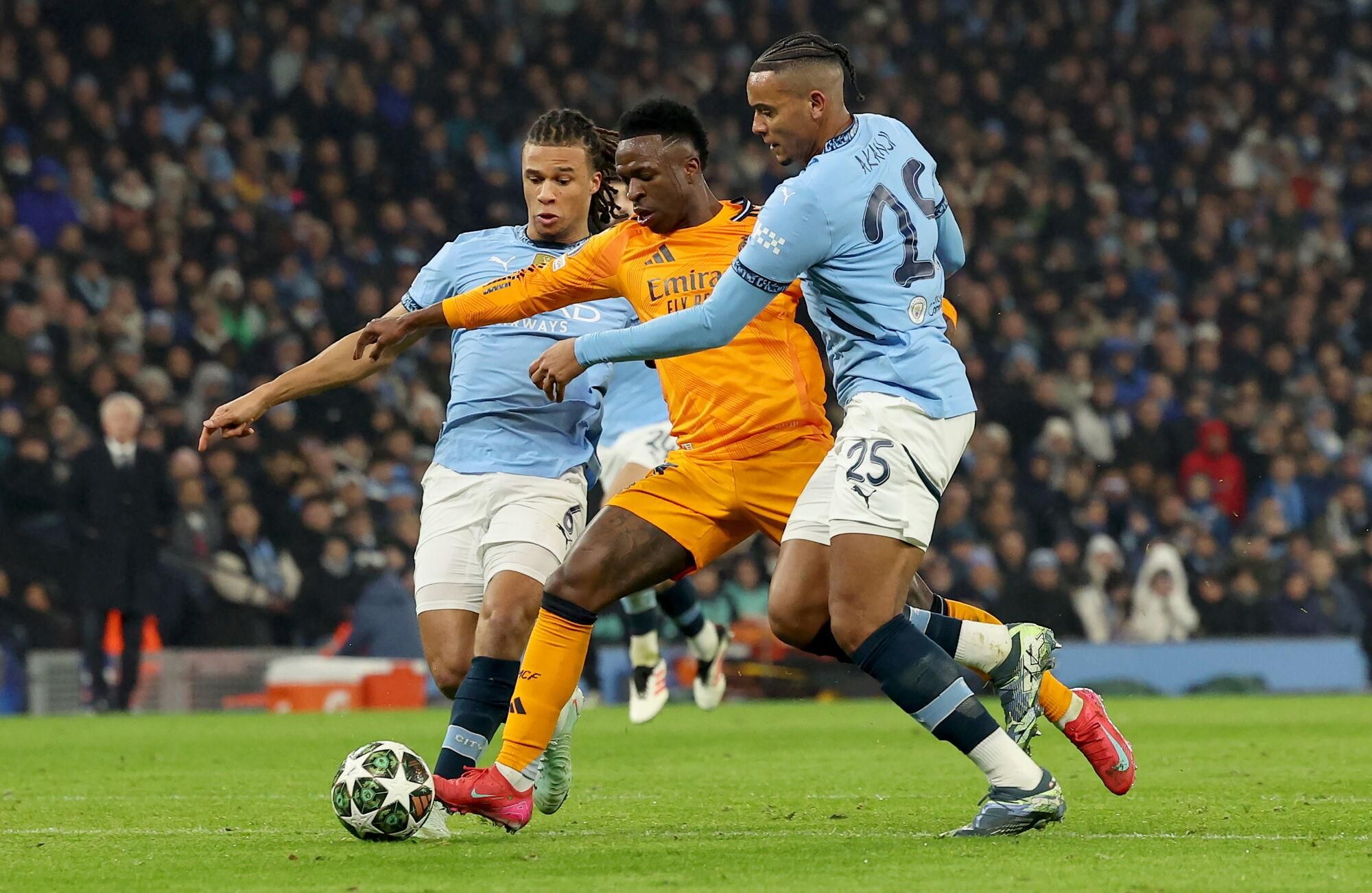 MANCHESTER (United Kingdom), 11/02/2025.- Nathan Ake (L) and Manuel Akanji (R) of Manchester City in action against Vinicius Junior of Real Madrid during the UEFA Champions League knockout phase play-offs 1st leg match between Manchester City and Real Madrid, in Manchester, Britain, 11 February 2025. (Liga de Campeones, Reino Unido) EFE/EPA/ADAM VAUGHAN