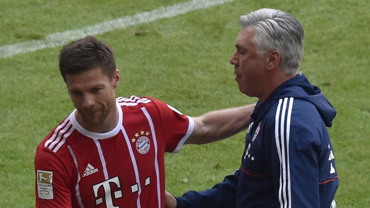 Xabi Alonso se abraza con su entrenador, Carlo Ancelotti, tras ser sustituido